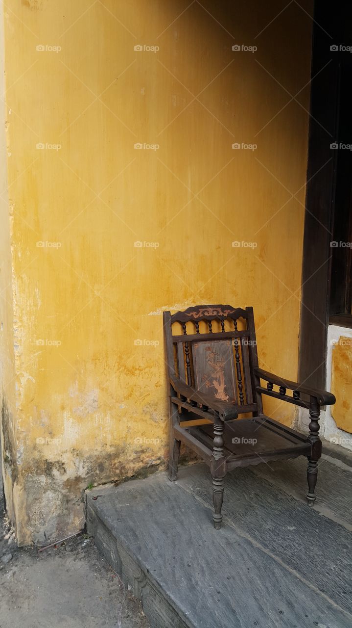 ancient empty chair on a yellow background