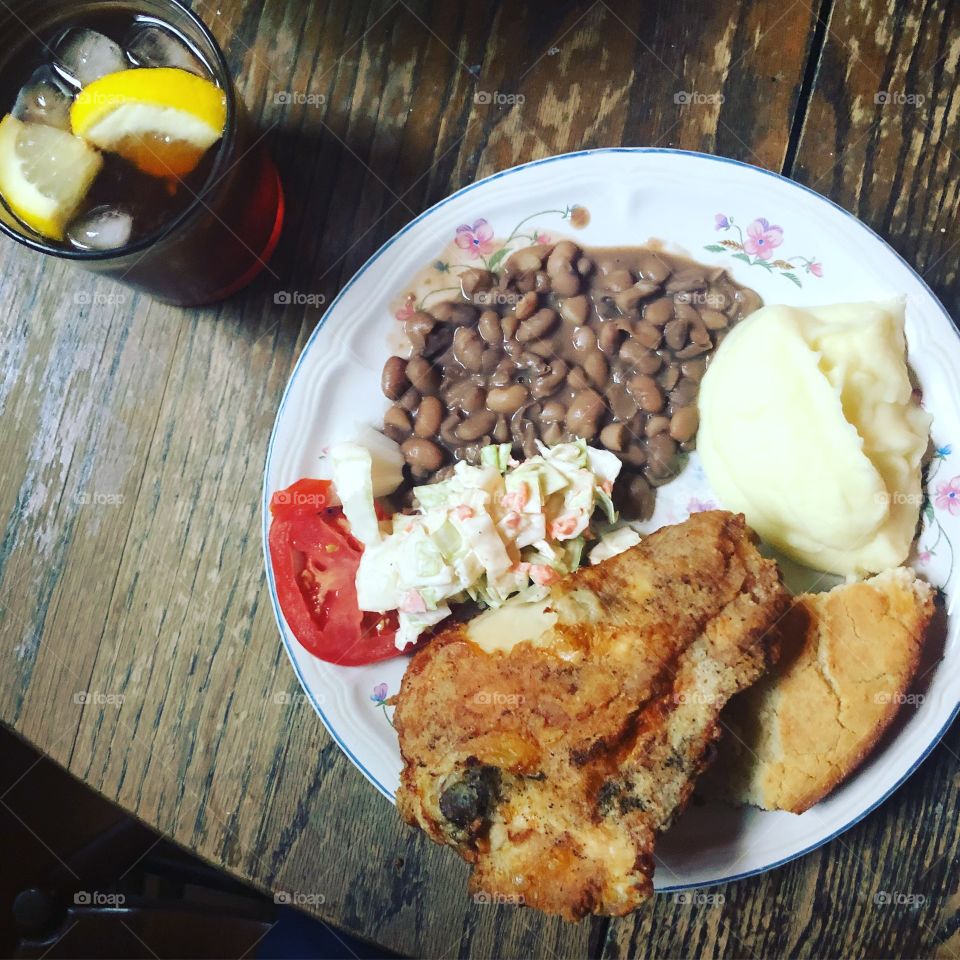 Mom’s home-cooking. Delicious fried chicken, pinto beans, mashed potatoes, cornbread, and coleslaw. Side of tomato and onion. Sweet tea to drink. A real southern meal. 