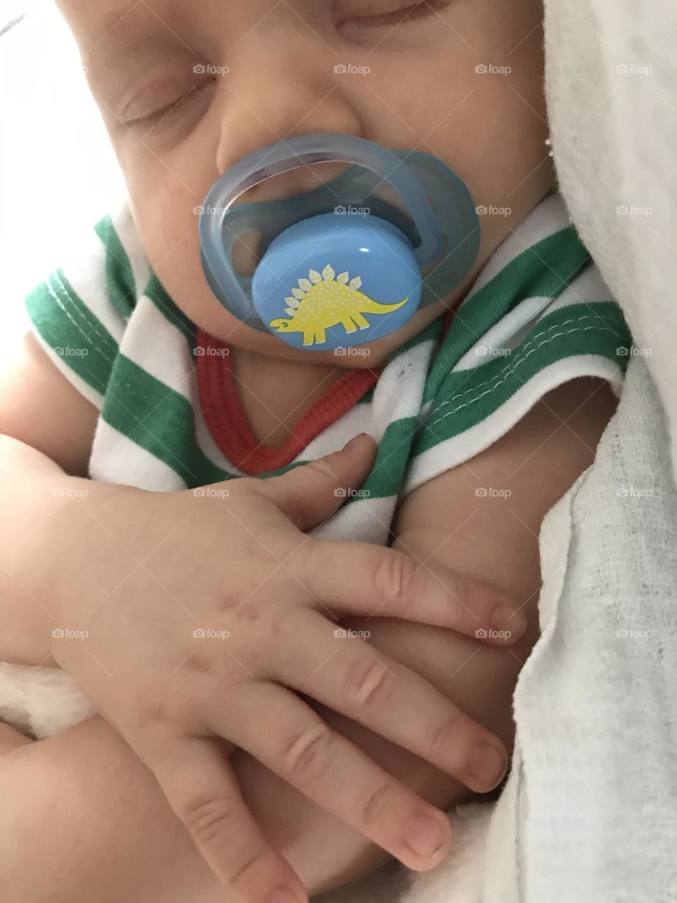 the baby sleeps with a pacifier in his mouth