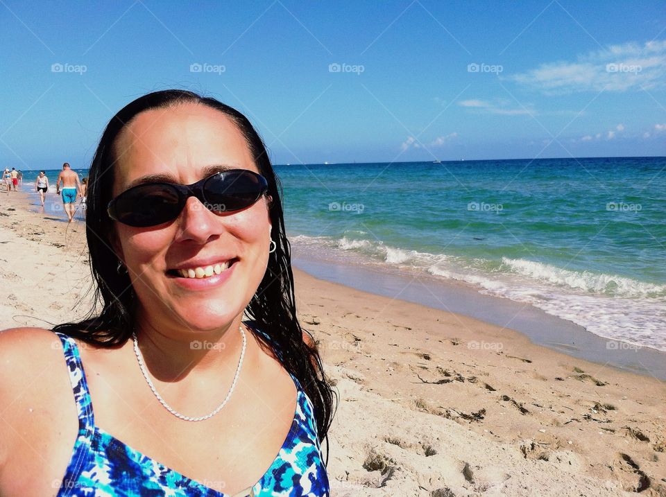 Smiling Girl on the Beach Wearing  Sunglasses