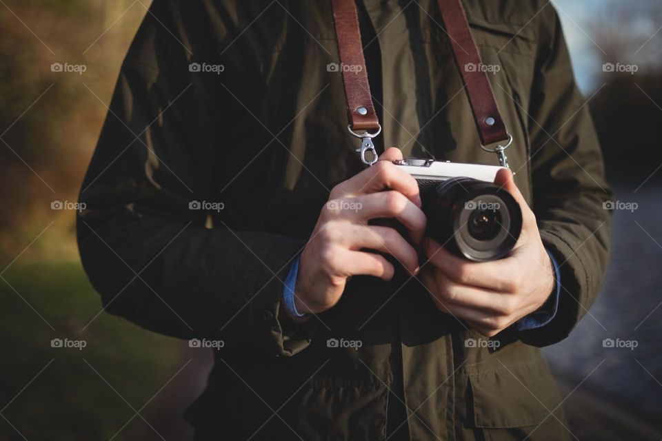 Man holding and adjusting the lens his camera