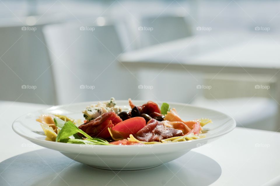 close-up of a young man eating a salad in a light kitchen