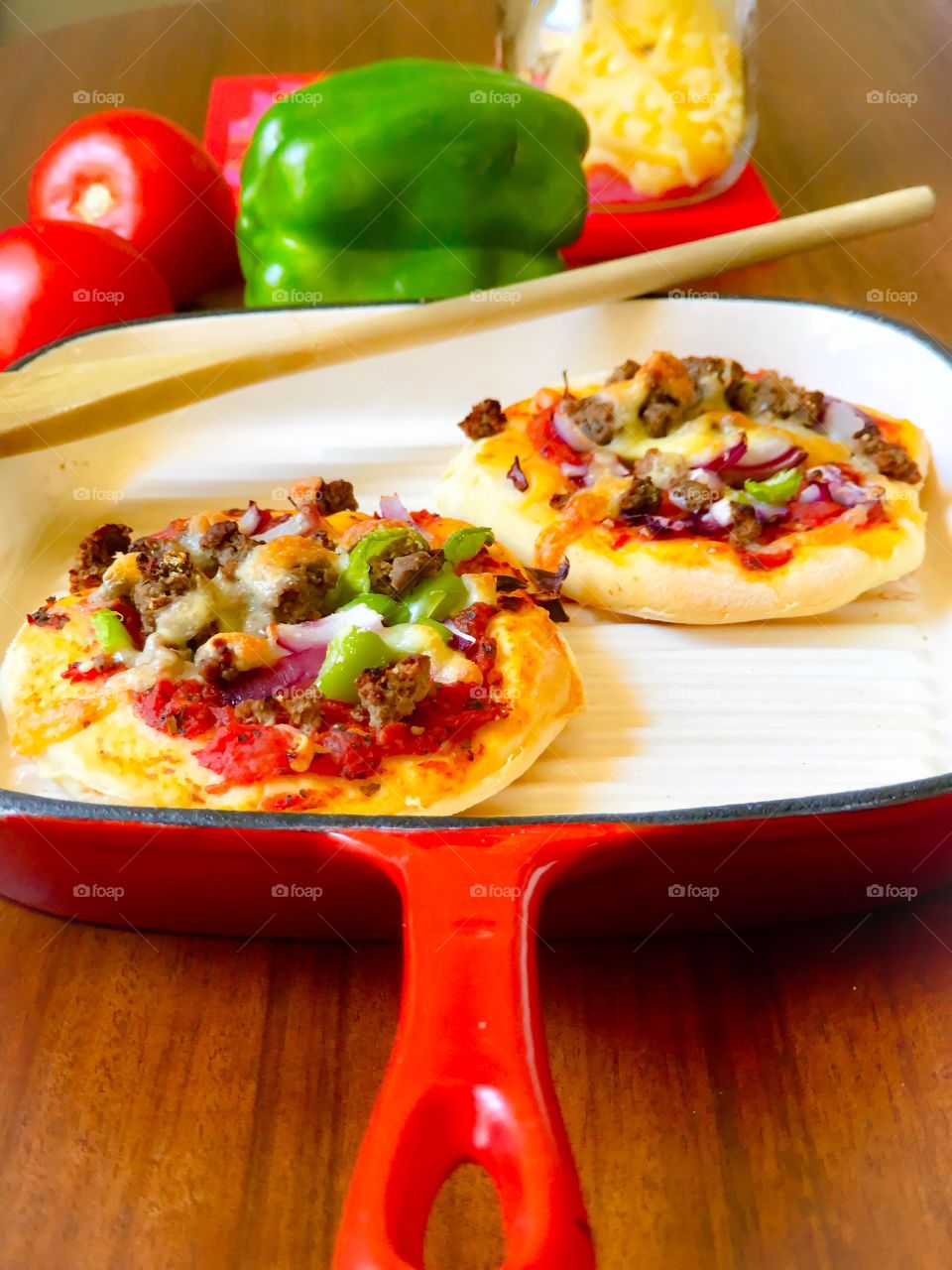 Farm fresh vegetables topped with fresh cheese atop homemade mini pizzas on red cast iron grill pan
