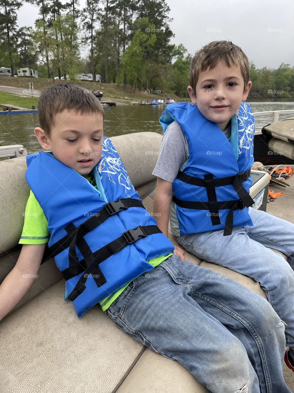 Boys riding on a pontoon boat and smiling 