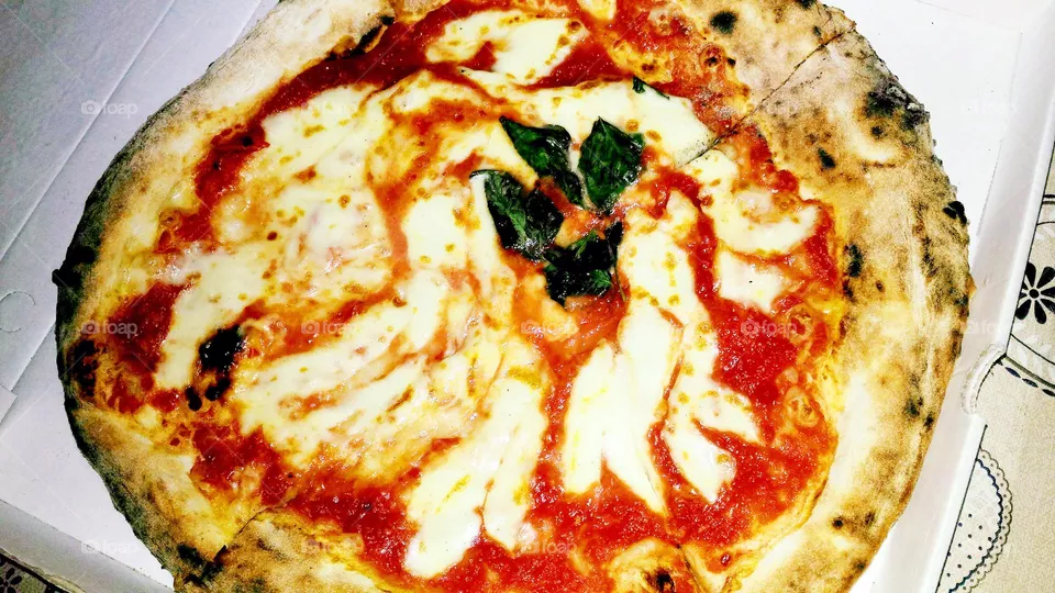 Original Pizza Margherita in its box prepared in a pizzeria of the Italian island Ischia