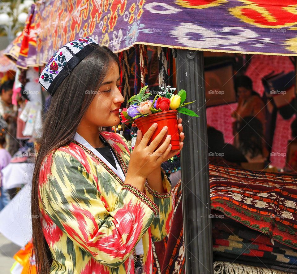 at the counter, a girl from Uzbekistan closed her eyes from the smell of flowers in a pot