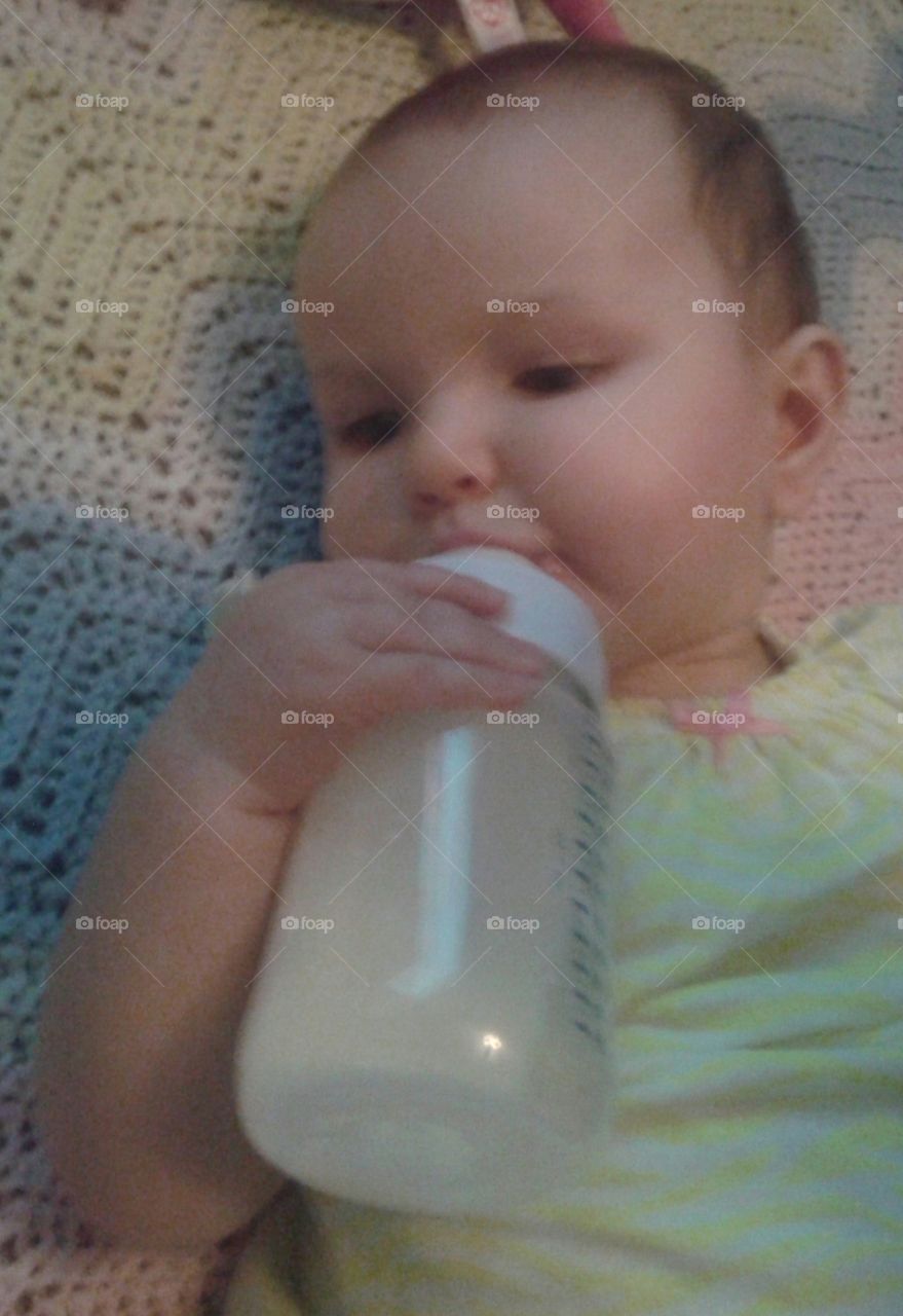Feeding. holding her bottle on her own