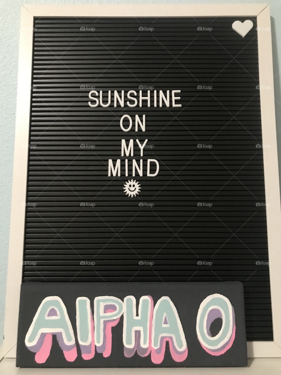 Aesthetic alpha omicron pi hand painted canvas in front of a letter board 