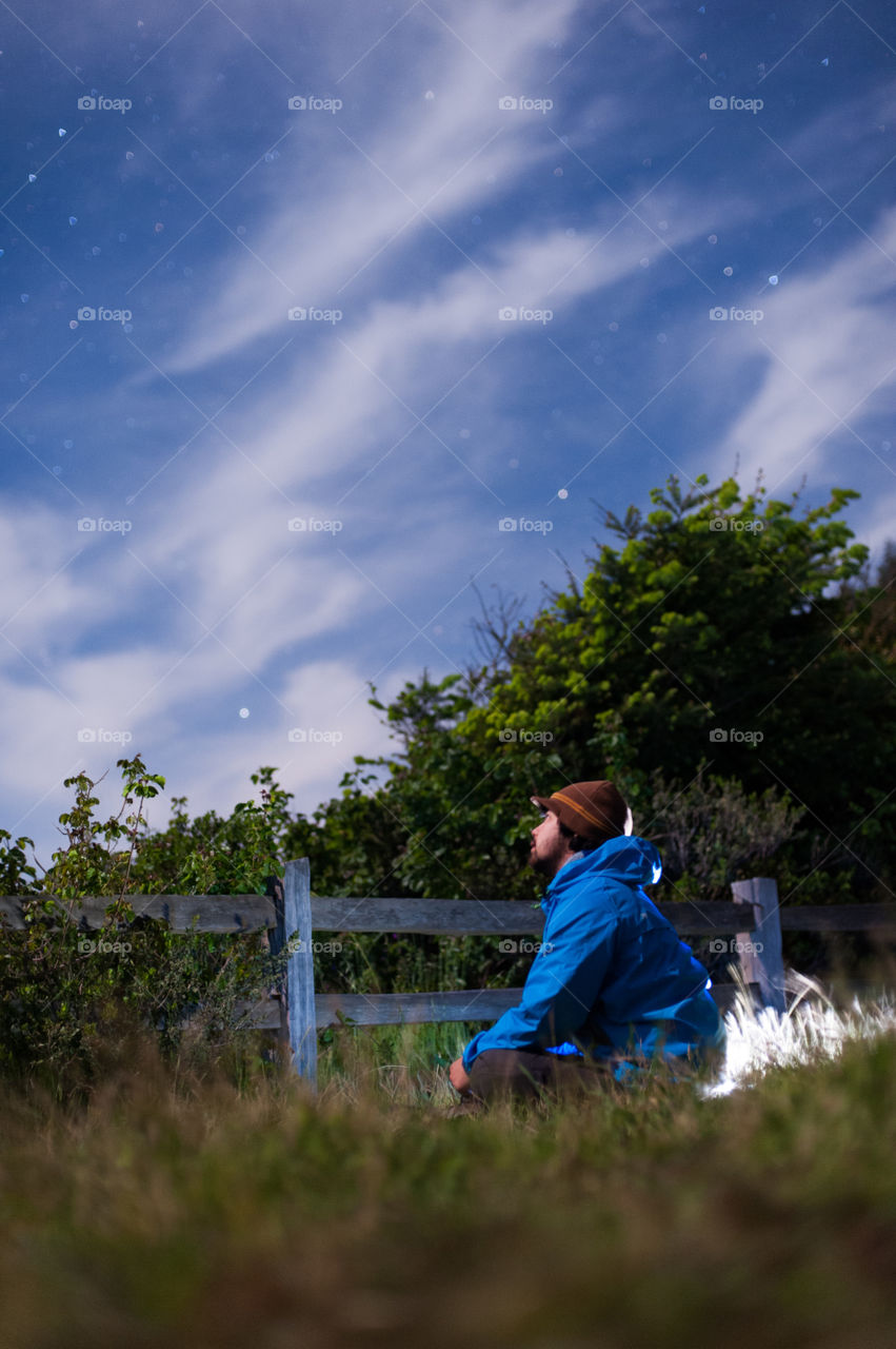 Man looking in star field during night