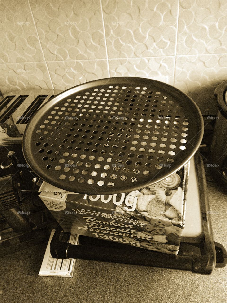 pizza thing on top of a box of broken biscuits in sepia tone