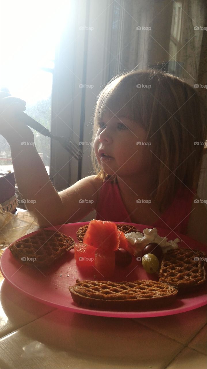 Small girl having her breakfast