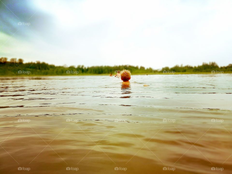 Todler boy first time swimming in lake.