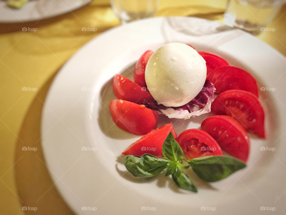 Fresh Italian caprese salad made with mozzarella cheese and sliced tomatoes 