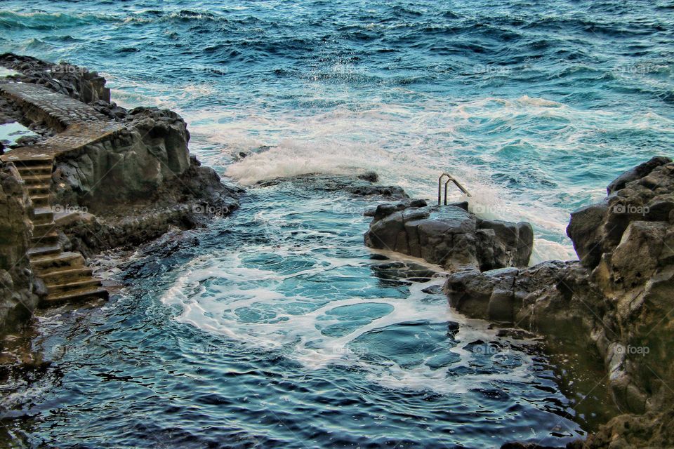 Stairs in rock and railing in the stormy atlantic ocean