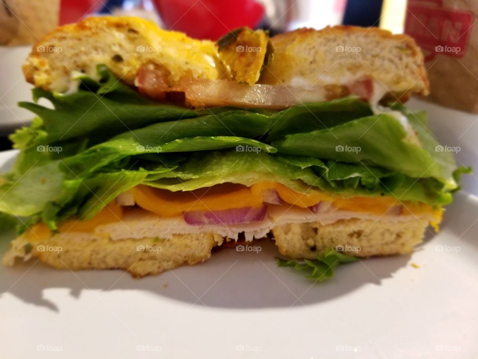 bagel with lettuce and bacon and cheese and ham