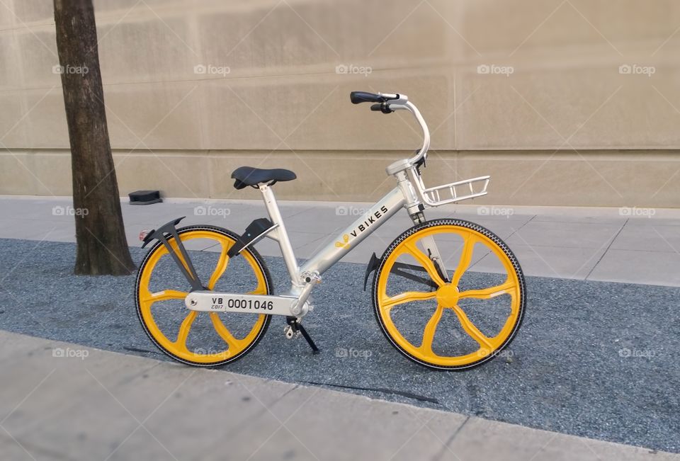 The yellow wheels on an urban bicycle