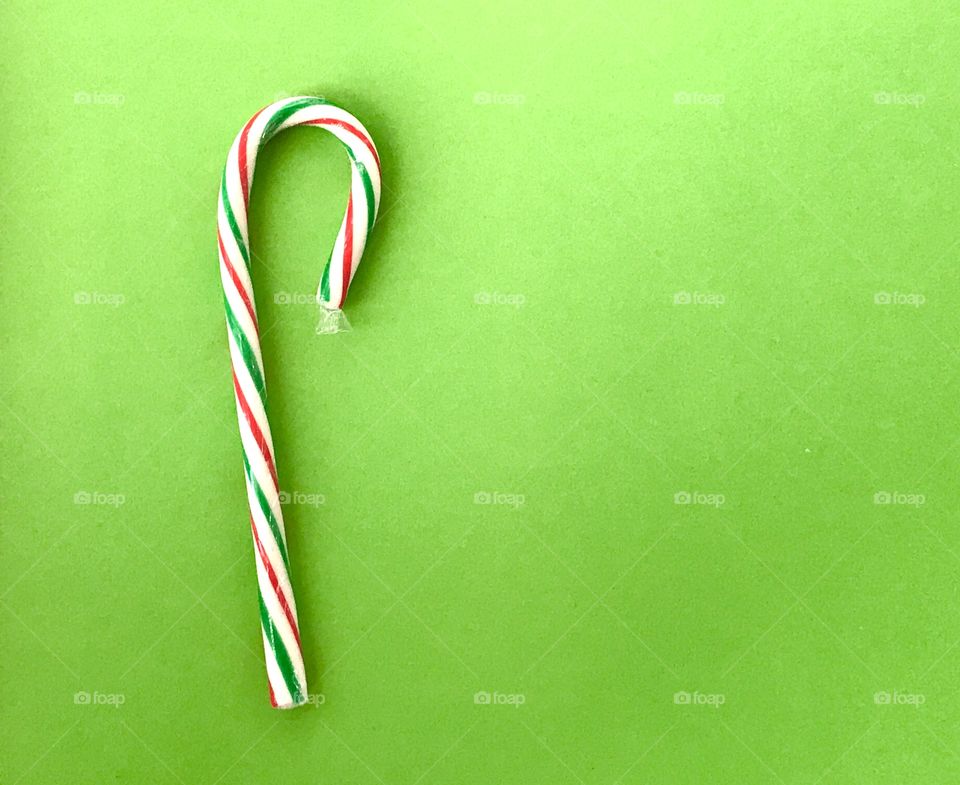 A candy cane on a green background 