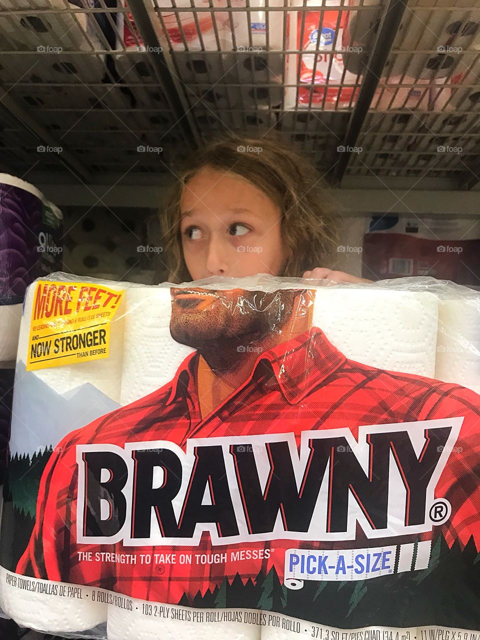 A funny little girl posing with the Brawny paper towels in the store. 