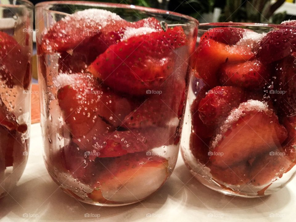 The strawberries dessert background. The strawberries in glasses with sugar
