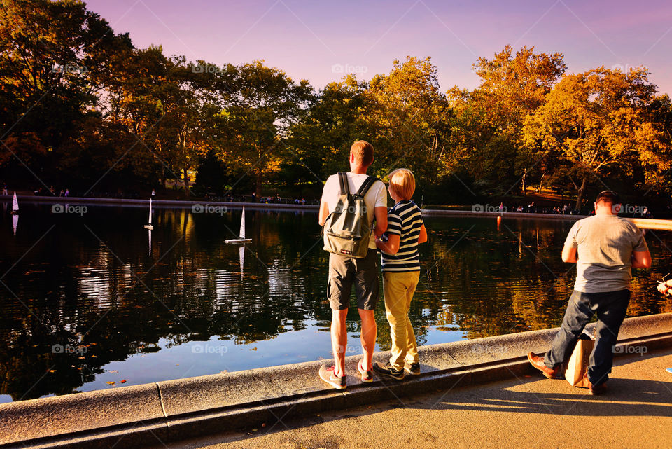 Central Park Sailboats. Boys sailing remote controlled sailboats in the park.