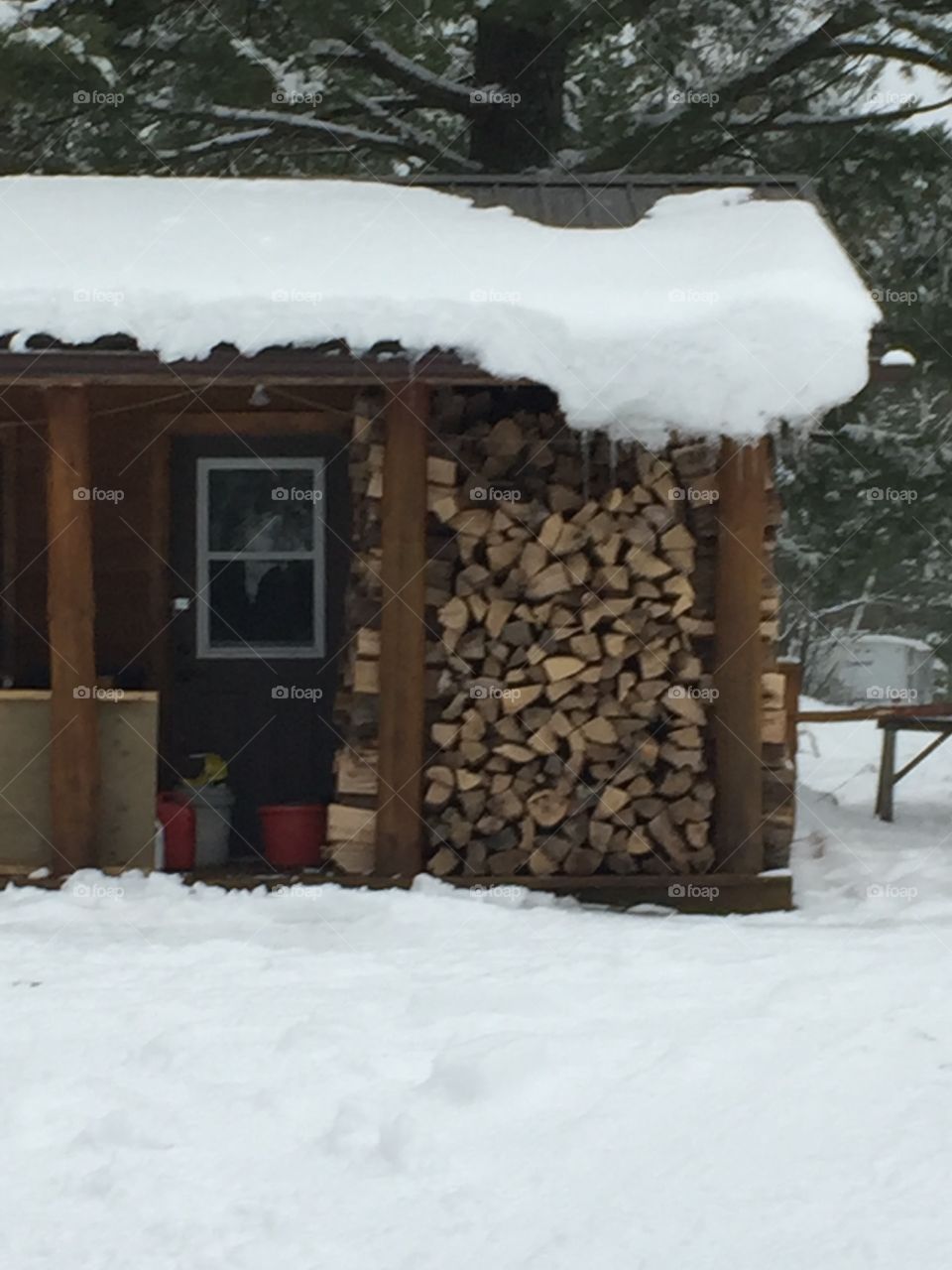 This cute little cabin is ready for winter wood piled up under the porch for easy access for this cold winter nights