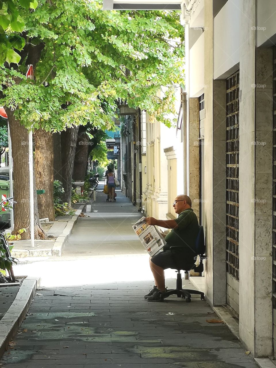 Elder reading newspaper on the street