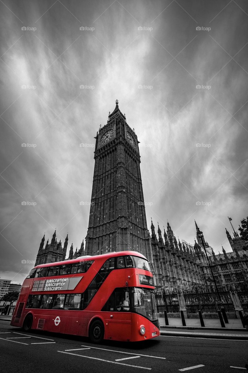 A Red Double-Decker Bus passing by the Big Ben - London, UK