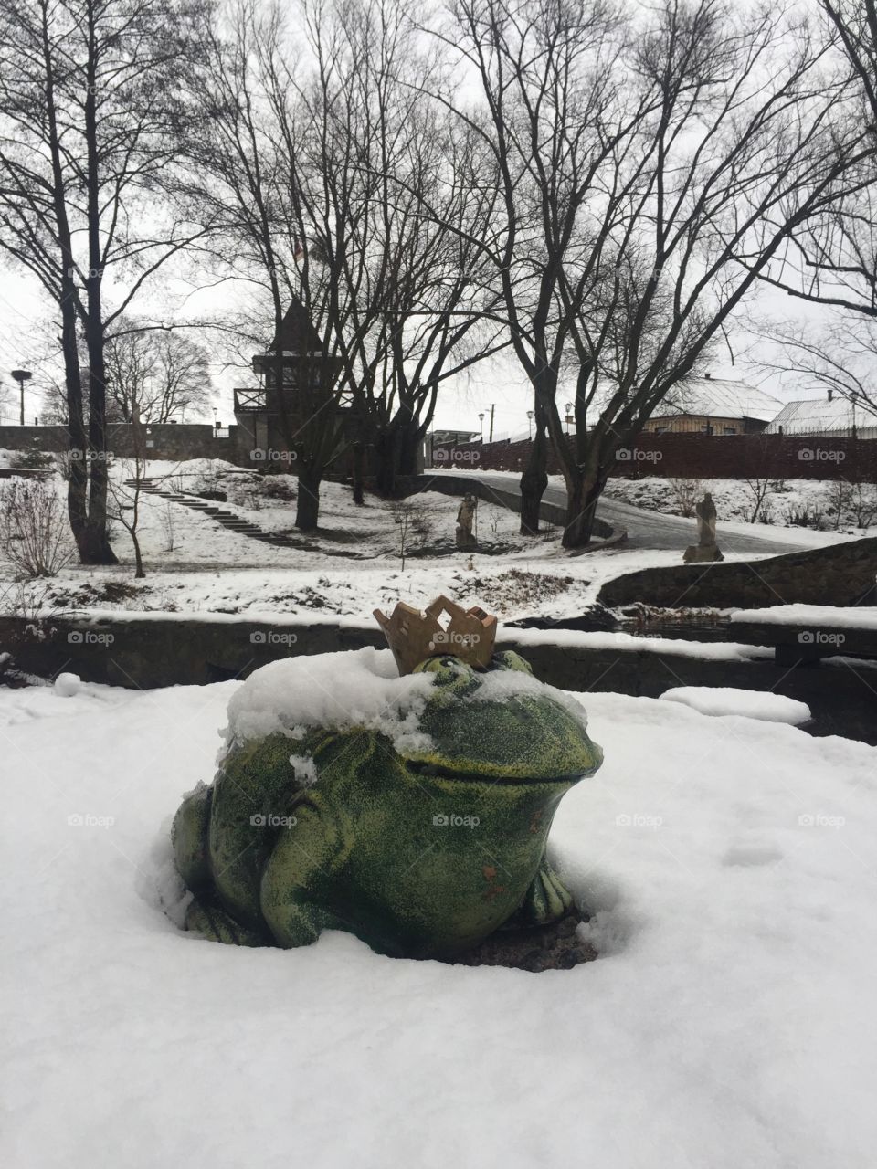 A sculpture of a princess frog in winter