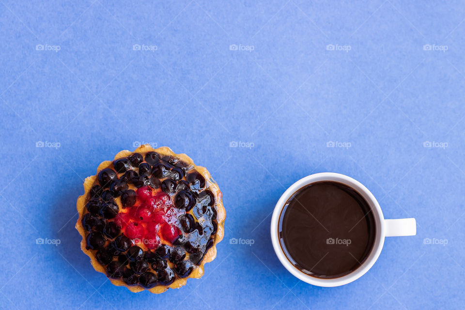 Top view to cup with coffee and dessert with berries.