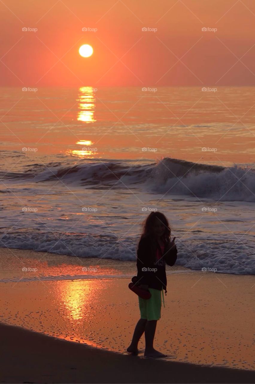 Collecting Shells. Little girl walking the beach at dawn, looking for seashells. 