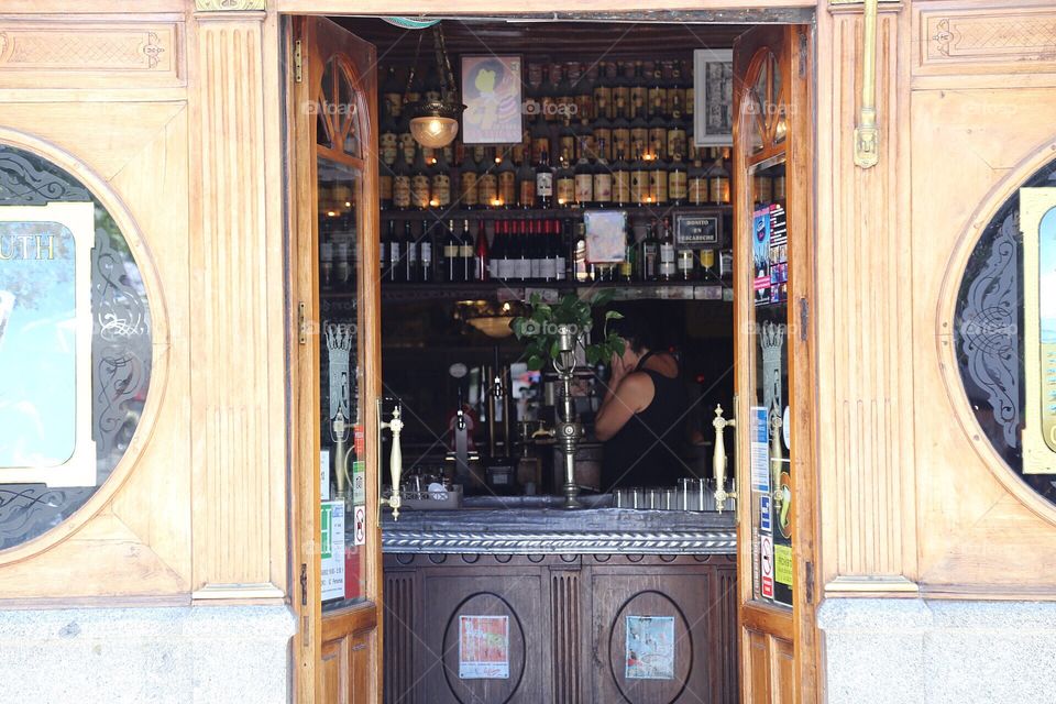 Open door to the bar where you can see all the bottles on the shelfs