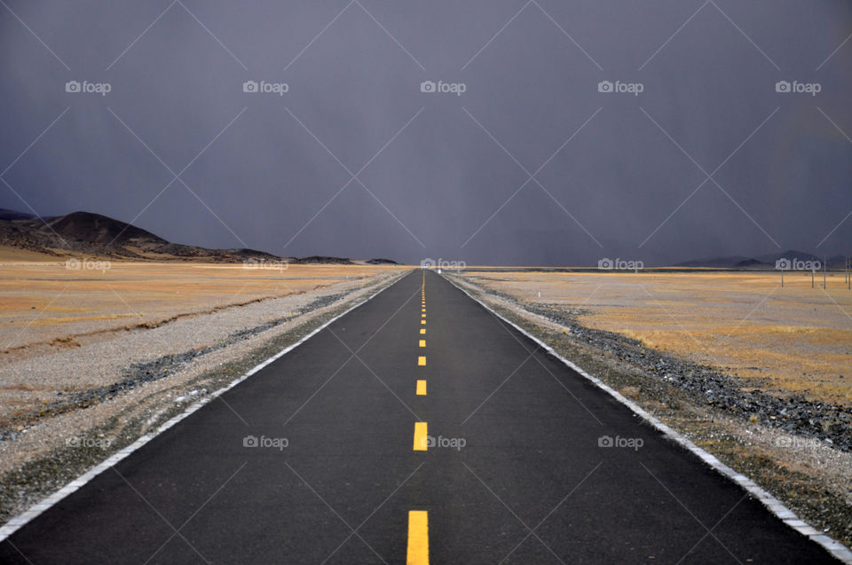 road to stormy clouds