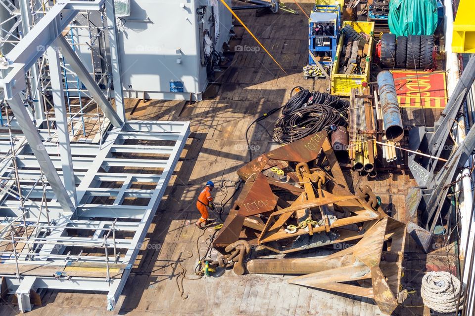 Offshore worker preparing rigging in preparation for anchor handling activities on a construction barge at oil field