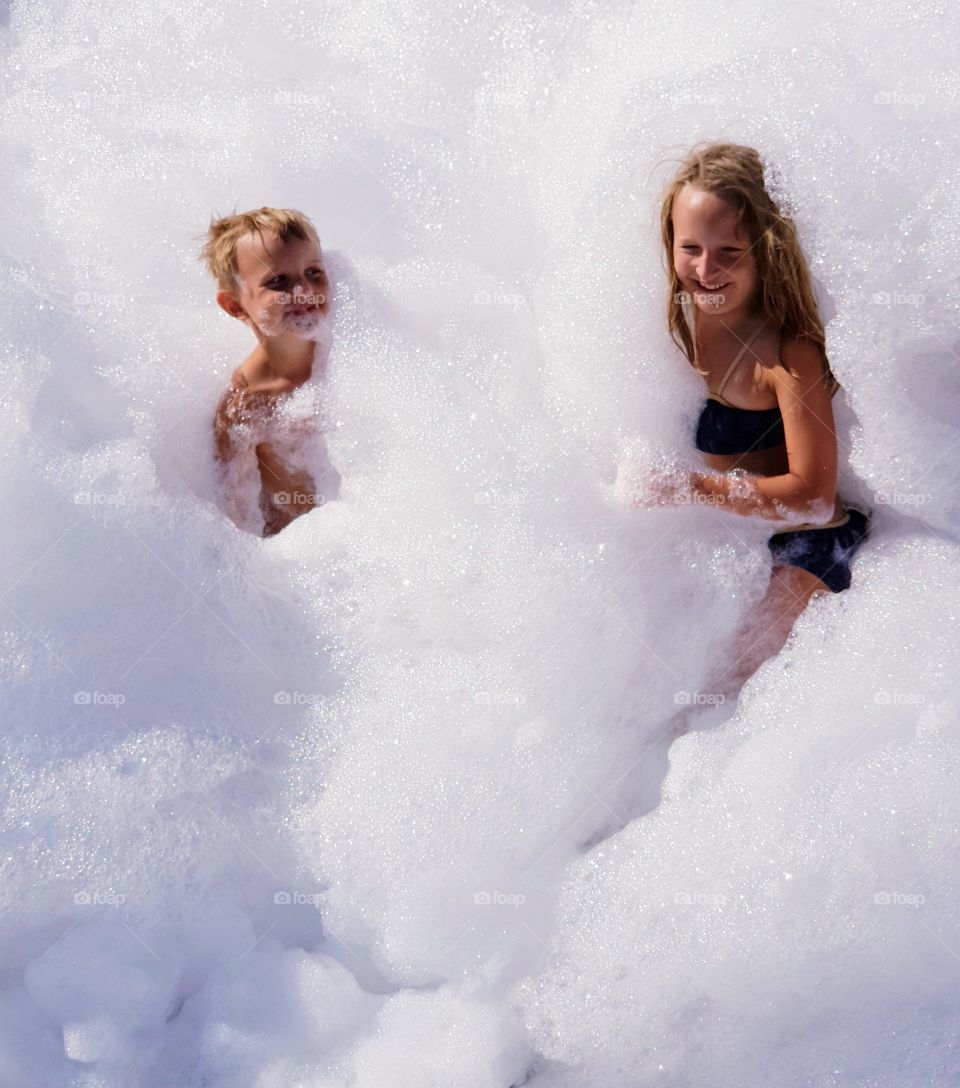 two children covered in foam