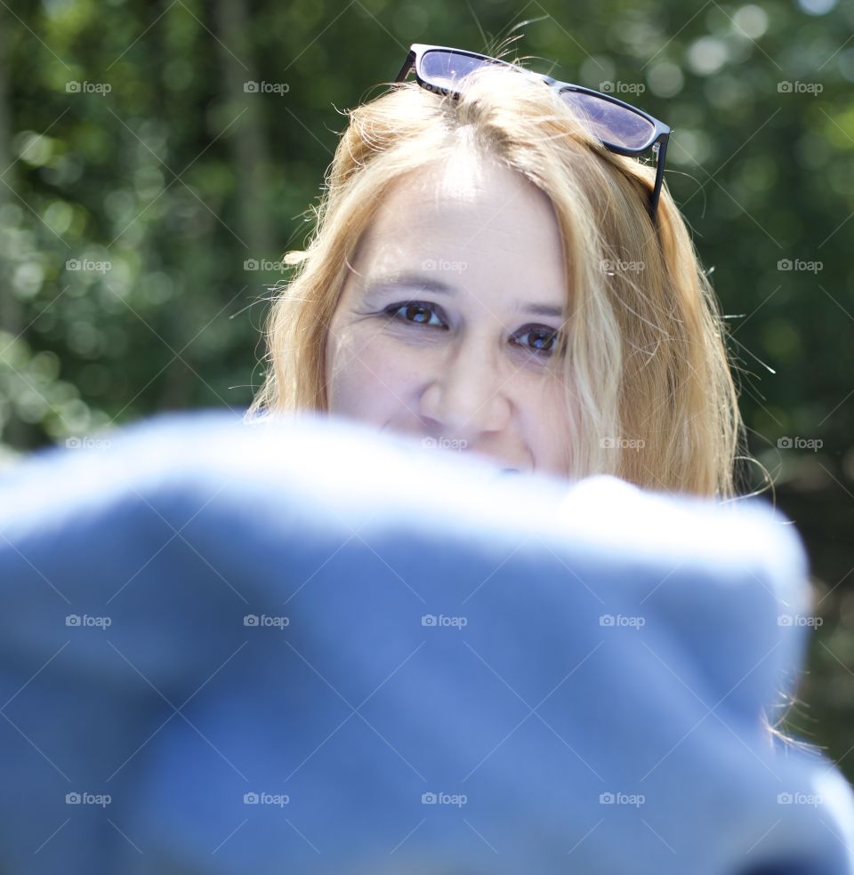 Summer fun; Woman throwing towel at photographer outdoors