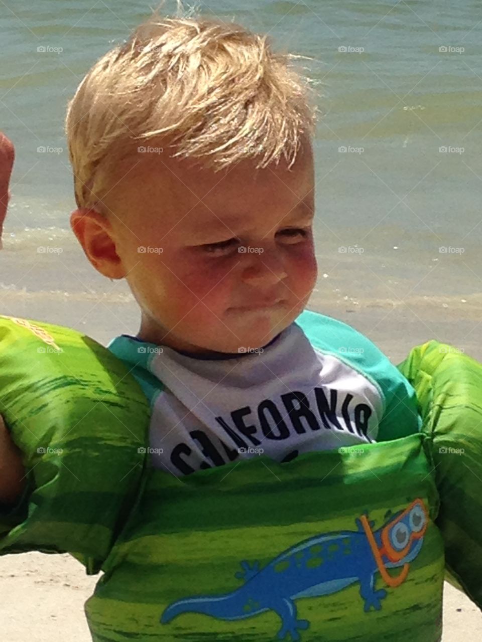 A handsome little boy with life jacket at beach