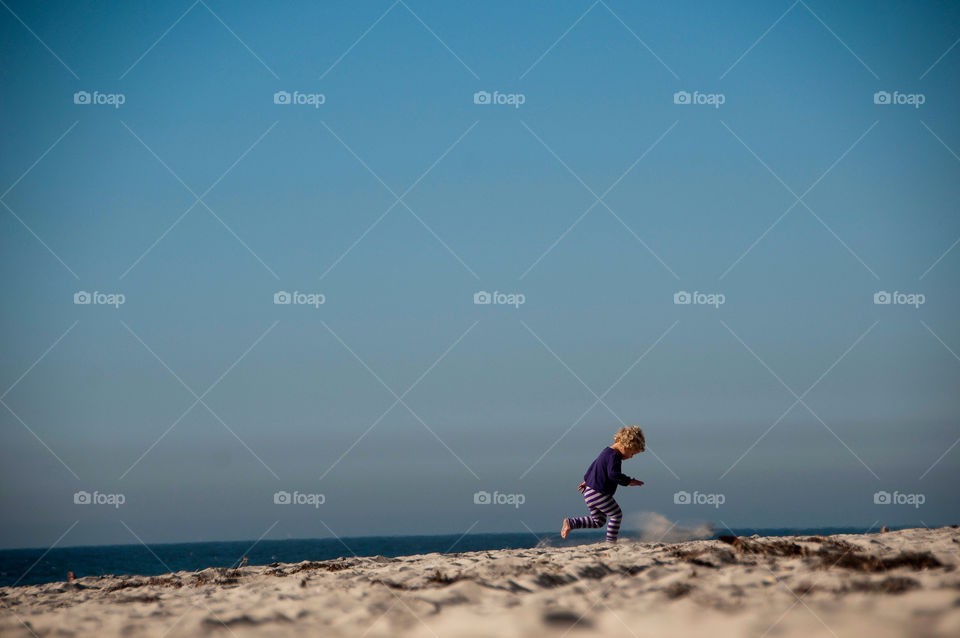 Little girl plays on the beach in sunny California