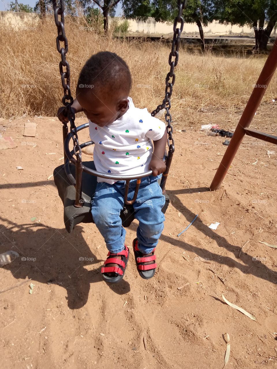 shadow of a swing and my baby on it. he is really having fun.