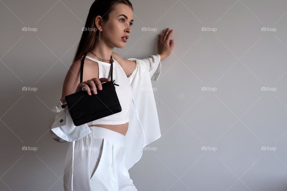 A girl in white with a branded bag