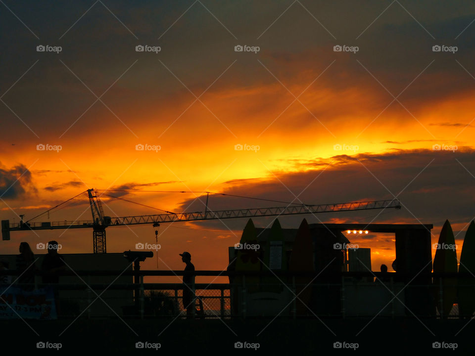 People strolling across the pier to catch a glimpse of this spectacular sunset over the Gulf of Mexico!