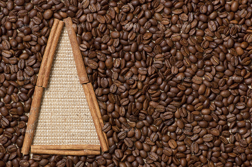 Christmas tree made of coffee beans and cinnamon sticks on sack