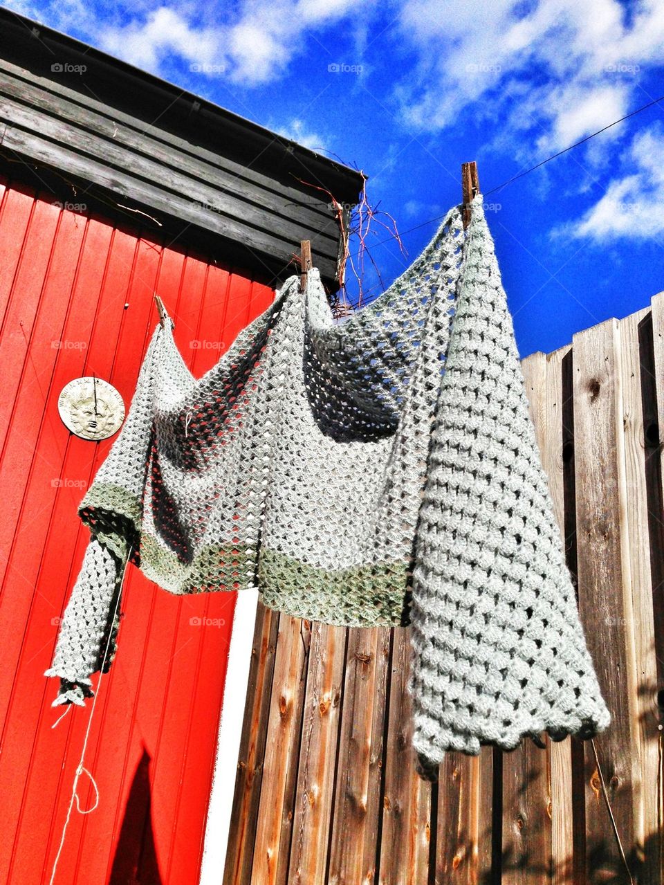 crocheted shawl against a blue sky