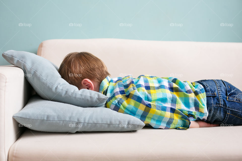 Boy lying on sofa