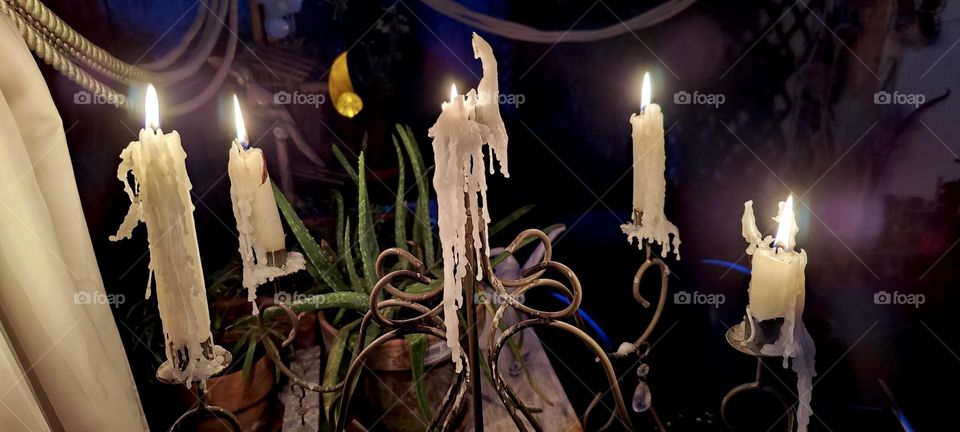 An ornamented metal candelabra in “Bavaria”, Germany holds lit white candles that are dripping wax and others that are still in newer condition for added hours of candlelight fun. It’s more romantic this way !!! 3023. Hypnotic Productions