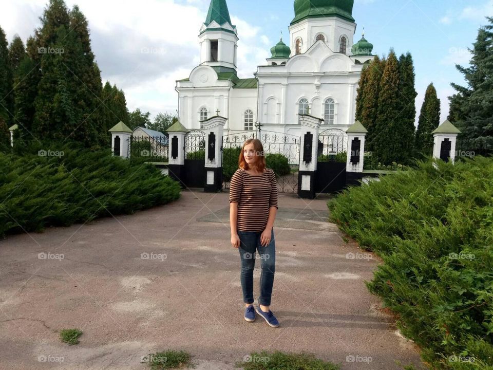 Photo session against the background of green city bushes and a church