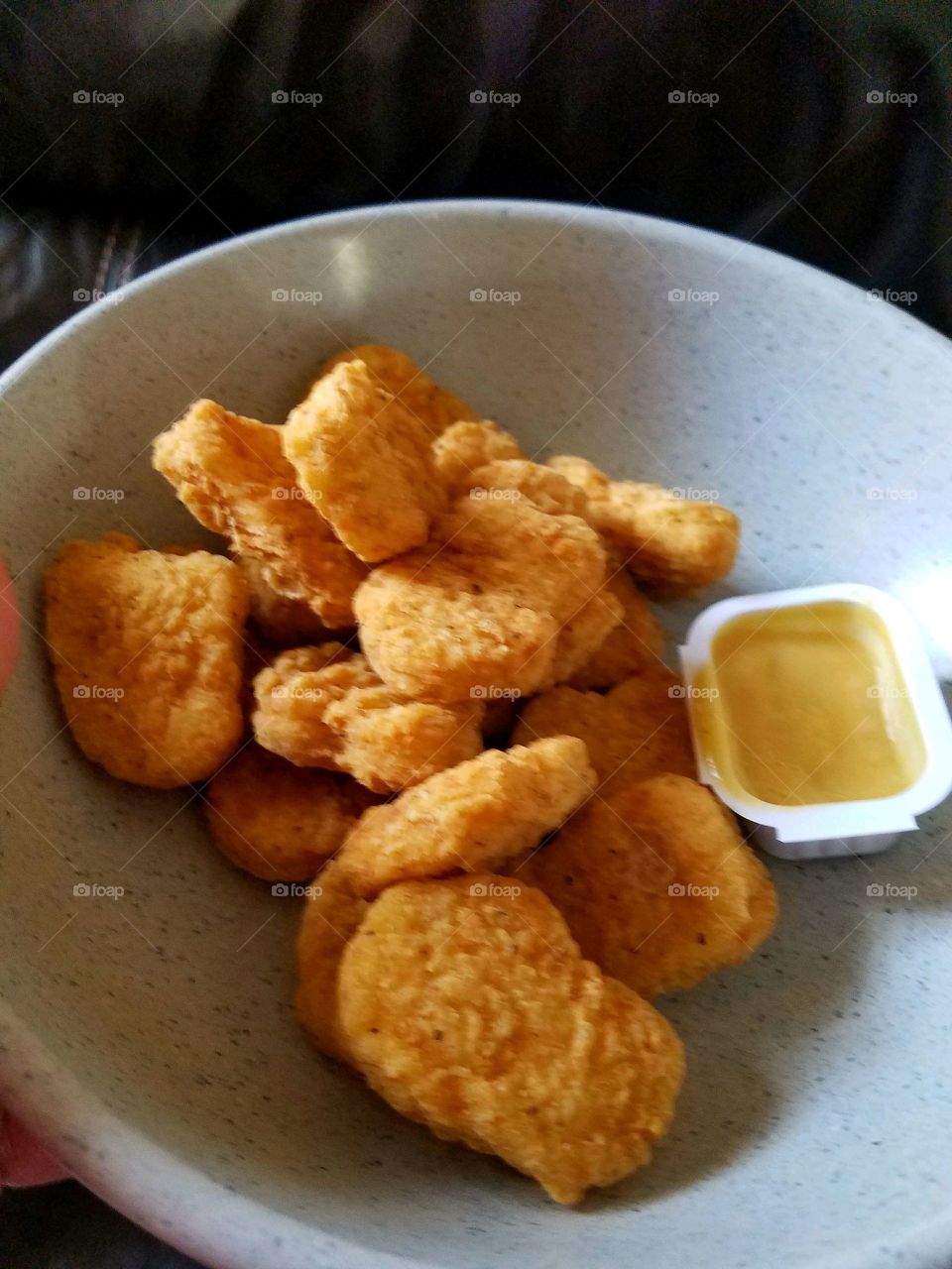 Chicken nuggets with sauce, favorite food served hot. Chicken tenders in a bowl with sauce.