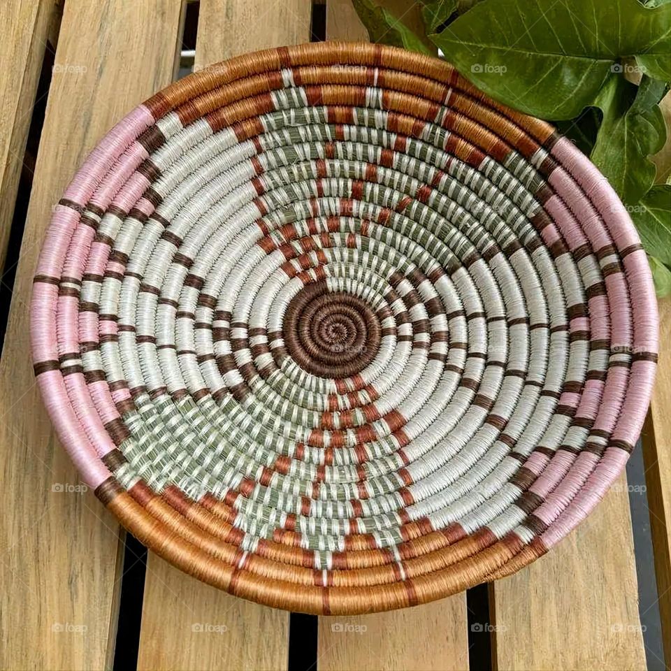 The image shows a group of hand -made dishes of wicker, decorated with colored embroideries with beautiful floral shapes, and is elegantly displayed in a warm corner that combines heritage and beauty, which gives the place an artistic spirit and attr