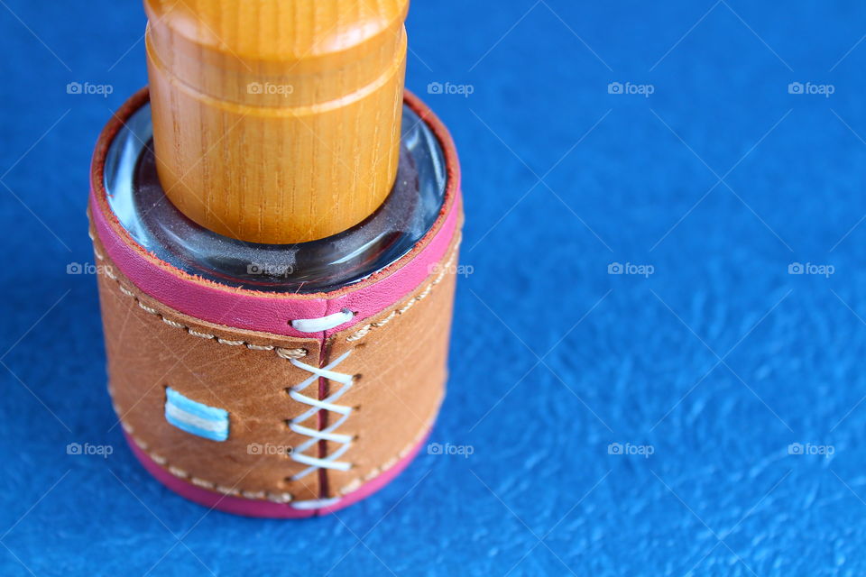 Leather strap of a perfume bottle on a blue background