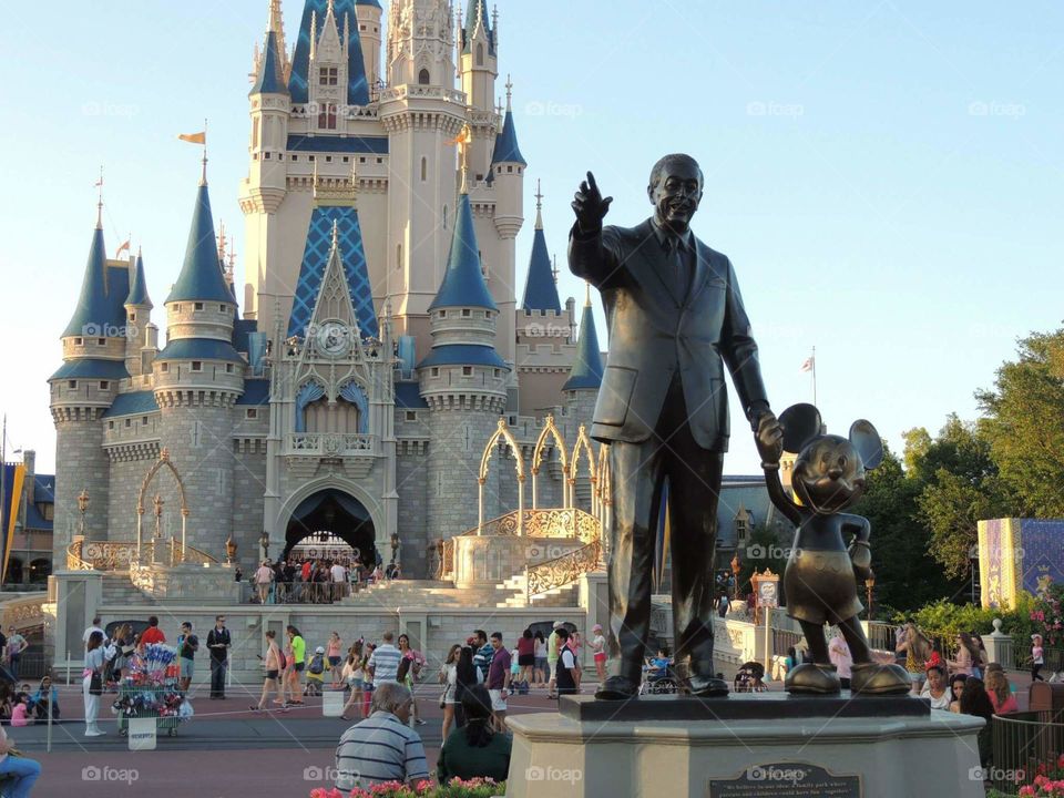 Walt Disney and Mickey Mouse look out over the world of imagination they built together as Cinderella Castle shines in the background.