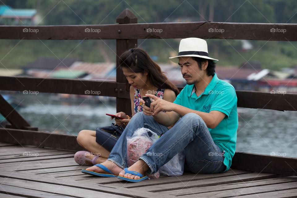 Lover sitting on the wood bridge